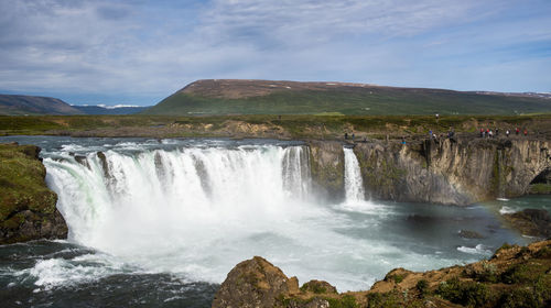 Scenic view of waterfall against sky