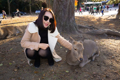 Full length of young woman sitting outdoors