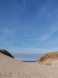 Scenic view of beach against blue sky