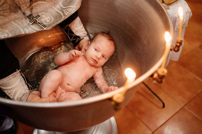 High angle view of person holding baby boy in bathroom