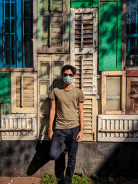 Full length of young man standing against built structure