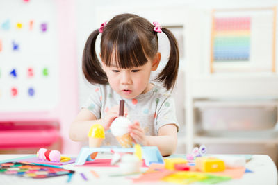 Portrait of cute girl with toys at home