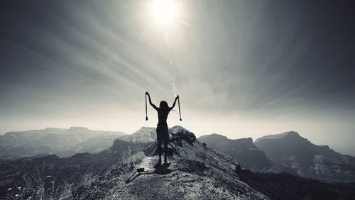 Silhouette man standing on mountain against sky