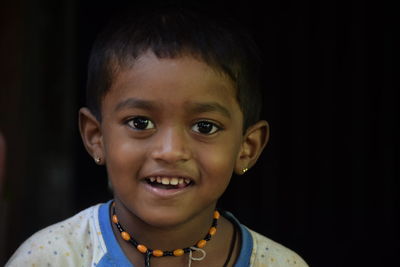 Close-up portrait of boy against black background