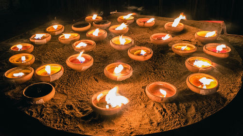 High angle view of lit candles in dark