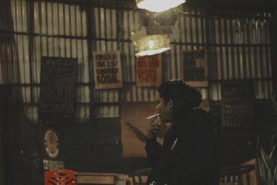 Side view of young man smoking cigarette