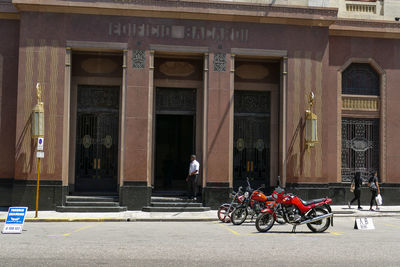 People on street against building in city