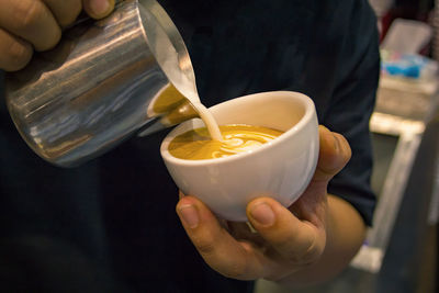 Close-up of man pouring tea cup