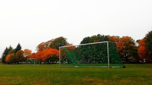 Trees on field against clear sky