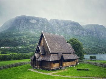 Built structure on field against mountain range, øye stave church