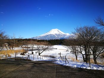 Scenic view of snowcapped mountains against blue sky