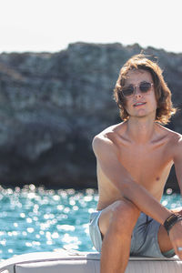 Casual portrait of man enjoying freedom on luxury yacht deck relaxing on boat summer vacation trip.