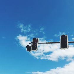 Low angle view of road signal against blue sky