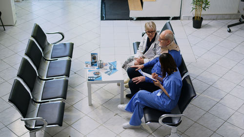 Rear view of woman using mobile phone while sitting on wheelchair