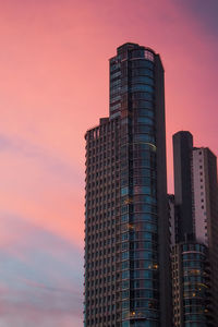 Low angle view of skyscraper against sky during sunset