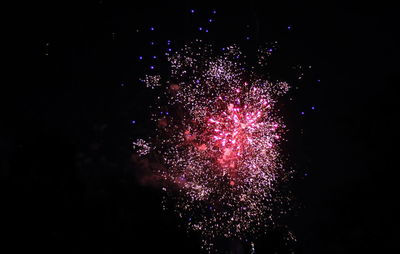 Low angle view of firework display at night