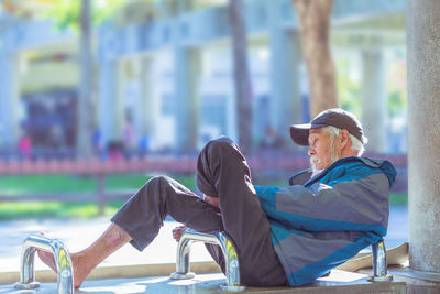 Side view of man sitting on bench