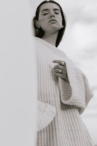 Woman looking away while standing against white background