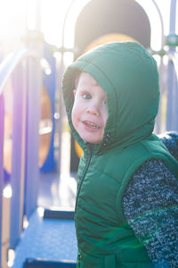 Portrait of smiling boy wearing warm clothing at playground