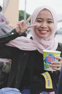 Portrait of a smiling young woman holding ice cream