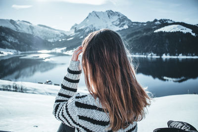 Woman against snow covered mountains and sky during winter