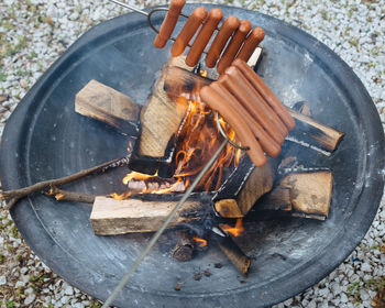 High angle view of sausages being cooked on fire
