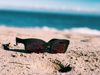 Close-up of sunglasses on beach