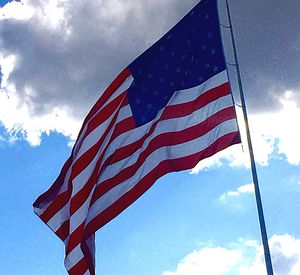 Low angle view of american flag against blue sky