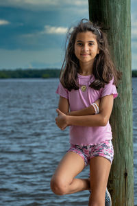 Portrait of young woman standing in sea