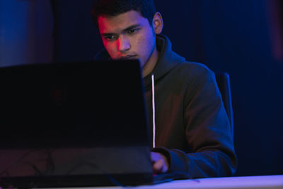 Young man using mobile phone while sitting on table