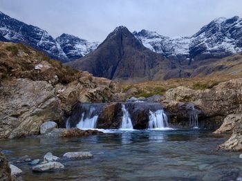 Scenic view of waterfall against mountains