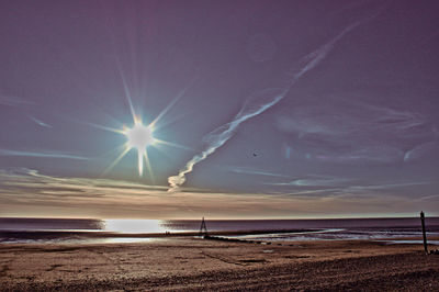 Scenic view of sea against bright sun