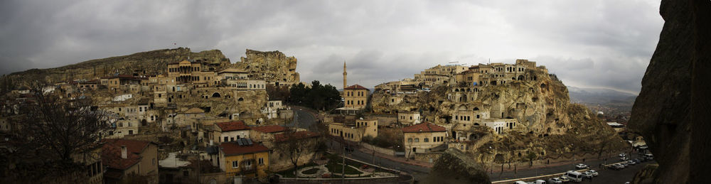 Panoramic view of buildings in town against sky