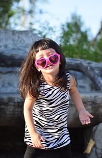 Smiling girl wearing heart shaped sunglasses