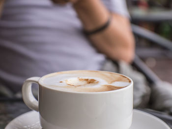 Midsection of man with coffee at table