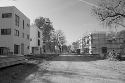 Empty road along buildings