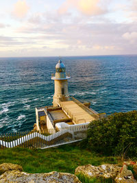 View of lighthouse by sea against sky