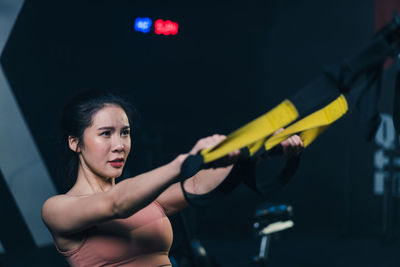 Portrait of young woman exercising in gym