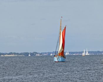 Sailboat sailing on sea against sky