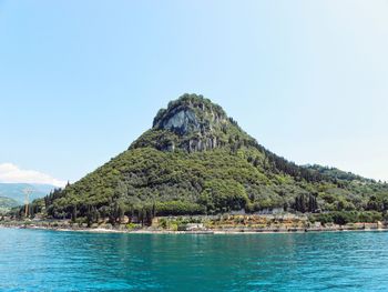 Scenic view of sea and mountains against clear sky