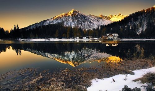 Scenic view of lake by snowcapped mountains against sky