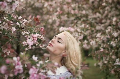 Portrait of young woman with pink flowers