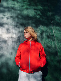 Young woman looking away while standing in rain