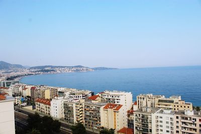 High angle view of townscape by sea against clear sky