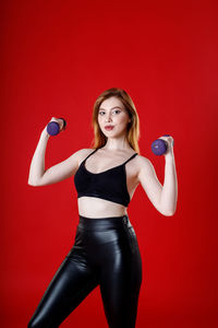 Portrait of a young woman against red background