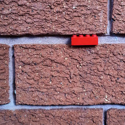 Close-up of brick wall with plastic toy brick