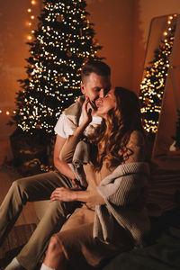 A romantic couple in love celebrates christmas holidays and new year in a cozy house at night