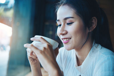 Close-up of young woman having coffee at cafe