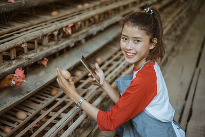Portrait of smiling young woman standing in factory