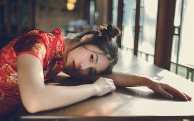 Portrait of young woman relaxing on table